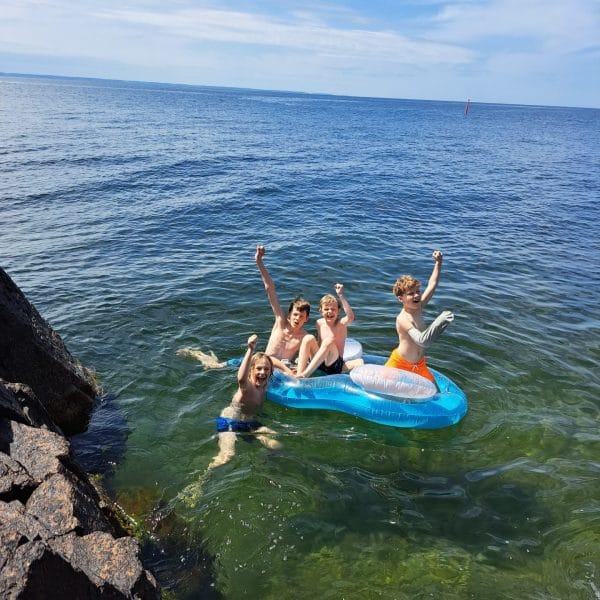 Arm grå drenge i vandet